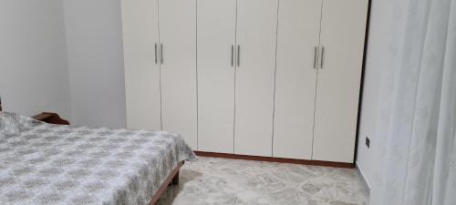 a bedroom with white cabinets and a bed at Jajo in Brindisi