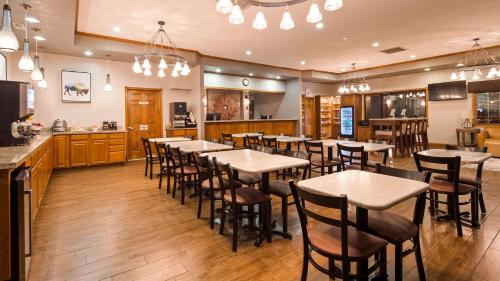 a restaurant with tables and chairs and a bar at Best Western Buffalo Ridge Inn Near Mt Rushmore in Custer