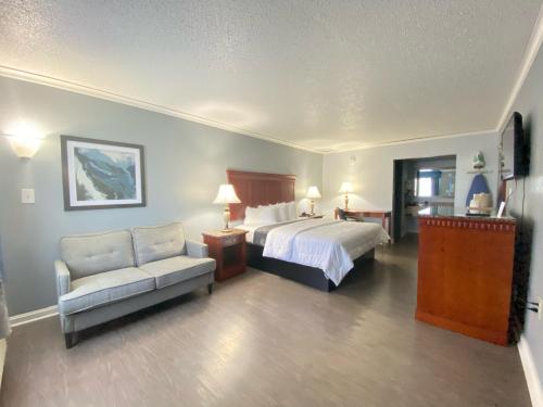 Habitación de hotel con cama y sofá en Quarters Inn & Suites, en Antioch