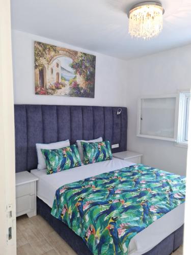 Maison Marine-Pieds dans l'Eau في كابو نيغرو: غرفة نوم مع سرير مزدوج كبير مع اللوح الأمامي الأزرق