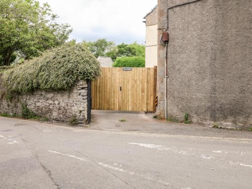 a wooden gate to a building with a stone wall at The Gables in Castleton