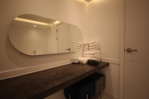 a bathroom with a mirror and towels on a counter at Hotel Vantt in Gwangju
