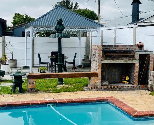 a backyard with a fireplace and a swimming pool at Welcome Estate Air B&B Hosting in Cape Town