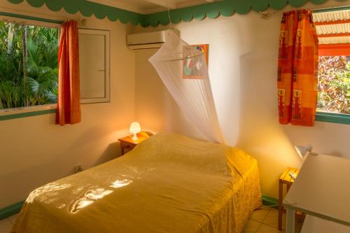a bedroom with a bed with a net on it at Les jardins de Pointe Noire in Pointe-Noire