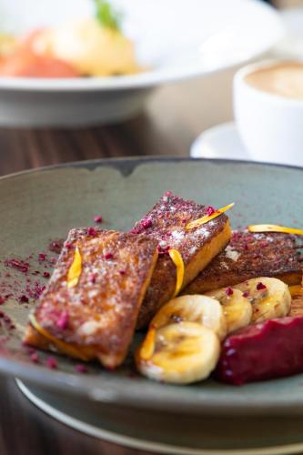a plate of food with bananas and toast at The George in Christchurch