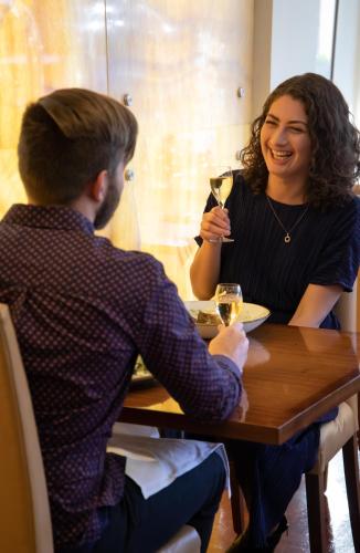 a woman sitting at a table with a man holding a glass of wine at The George in Christchurch
