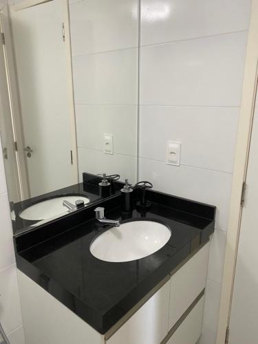 a bathroom with a sink and a mirror at Apto Top Custo-Benefício Qualidade e preço que surpreendem in Maceió