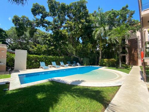 a swimming pool in the yard of a house at Villa Tendenza Condo in Playa del Carmen