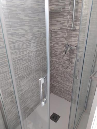 baño con ducha y puerta de cristal en Apartamento en primera línea de playa, en Laxe
