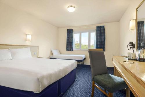 a hotel room with a large bed and a desk at Days Inn Sutton Scotney North in Sutton Scotney