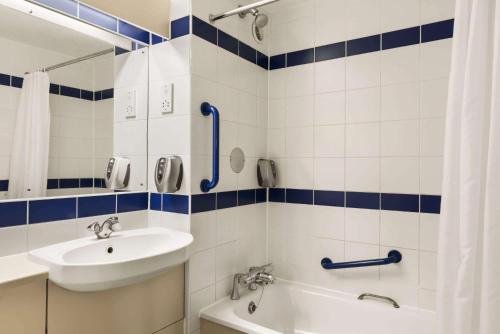 a bathroom with a sink and a toilet and a tub at Days Inn Sutton Scotney North in Sutton Scotney