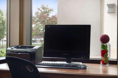 a computer monitor and printer on a desk at Ramada by Wyndham Newark/Wilmington in Newark
