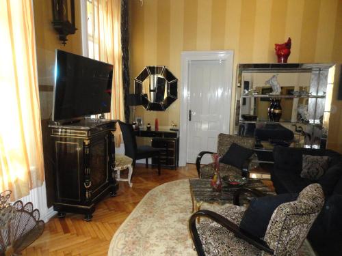 a living room with a couch and a television at Boudoir Budapest Apartment in Budapest
