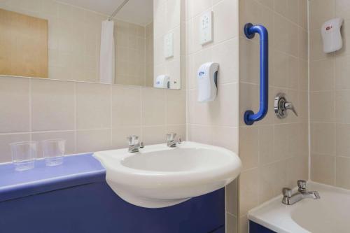 a bathroom with a sink, toilet and mirror at Days Inn Magor in Magor