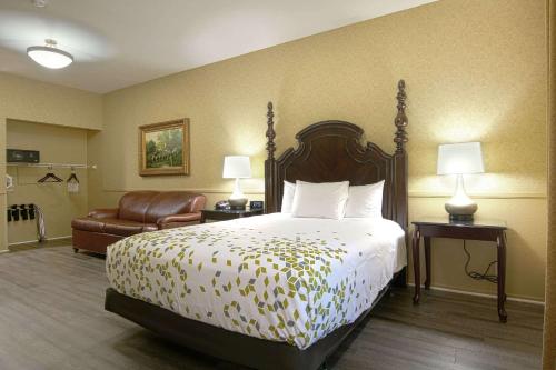 a hotel room with a bed and a chair at Azure Hotel&Suites Ontario Trademark Collection by Wyndham in Ontario