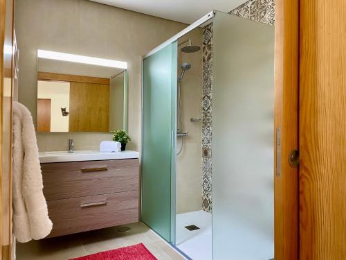 a bathroom with a glass shower and a sink at Casa do Pomar - Eido do Pomar in Arcos de Valdevez
