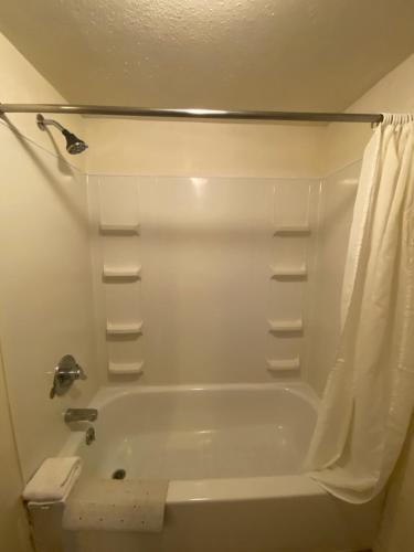 a bathroom with a white tub and a shower at Round-Up Motel in Cheyenne
