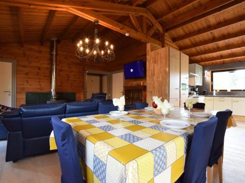 a dining room with a table and chairs and a chandelier at Cosy chalet in Durbuy in a beautiful hiking area in Durbuy