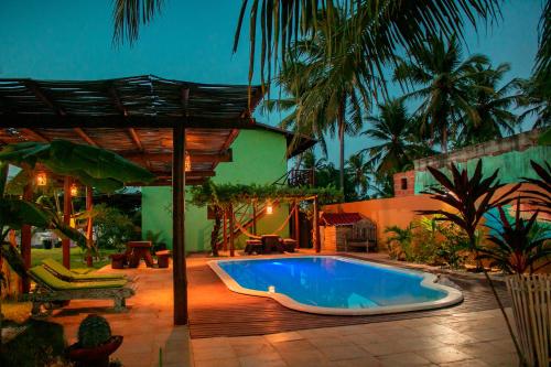 uma piscina num quintal com um guarda-sol em Pousada Curva dos Ventos em Icaraí