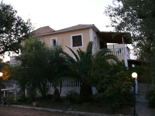 a white house with trees in front of it at Areti Orfeas Studios in Vasilikos