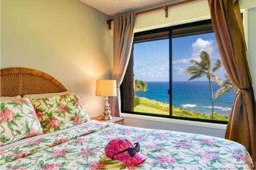a bedroom with a bed with a view of the ocean at Sealodge J9 in Princeville