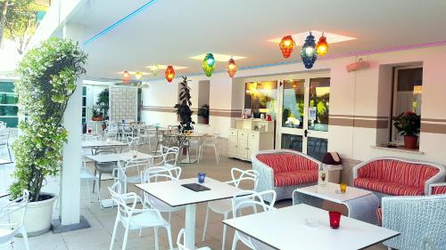 a restaurant with tables and chairs on a patio at Hotel Mediterraneo in Lignano Sabbiadoro