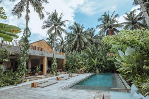 a villa with a swimming pool and palm trees at Surfing Temple Hotel Boutique in General Luna
