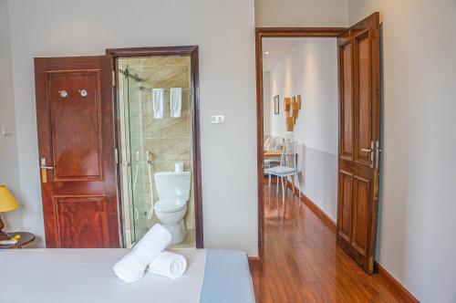 a bathroom with a toilet and a glass shower at WECOZY HANOI - Railway Side, The Old Quarter in Hanoi