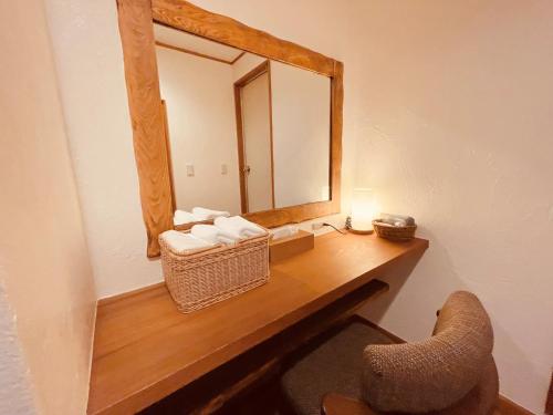 a bathroom with a vanity with a mirror and a chair at Nikko Akarinoyado Villa Revage in Nikko