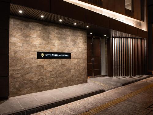 a building with a sign on the side of it at Hotel Vista Matsuyama in Matsuyama