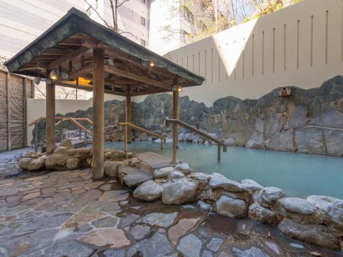 a pool of blue water with a wooden structure at Noboribetsu Manseikaku in Noboribetsu