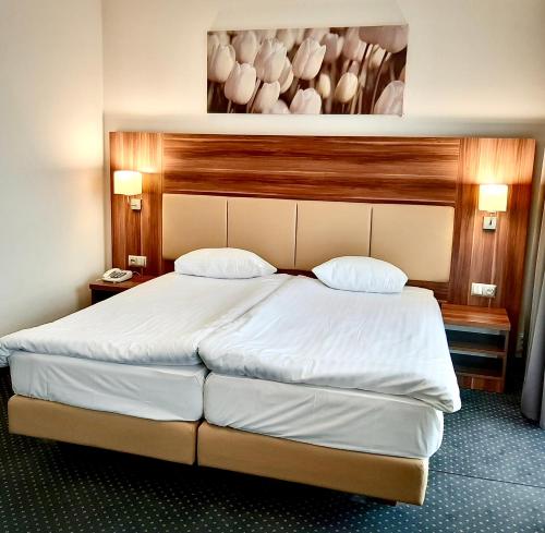 a bedroom with a large white bed with two pillows at Poleczki Residence Apartments in Warsaw
