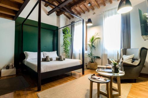 a bedroom with a four poster bed with a green wall at Castelmenardo39 in Treviso