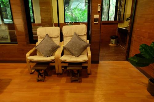two chairs with pillows on them in a room at Namtok Sarika Resotel in Nakhon Nayok