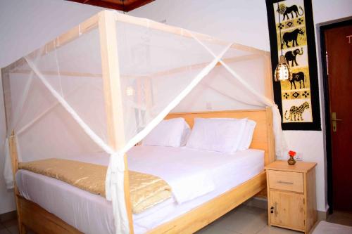 a bedroom with a white bed with a canopy at Volcano View in Ruhengeri