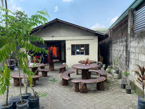 a patio with wooden tables and benches in front of a building at Jow's Place in Tarlac