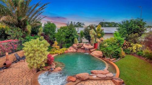 a swimming pool in a yard with a waterfall at Williams Lodge in Yungaburra