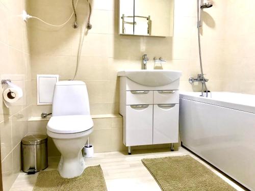 a bathroom with a toilet and a sink and a tub at Комфортные апартаменты Smart in Khmelëva