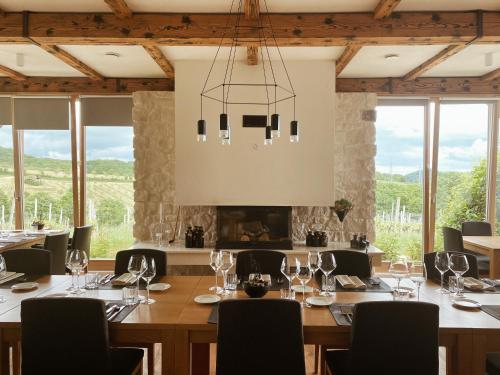 a dining room with a table and chairs and windows at Tri lučke Hotel & Restaurant in Krško
