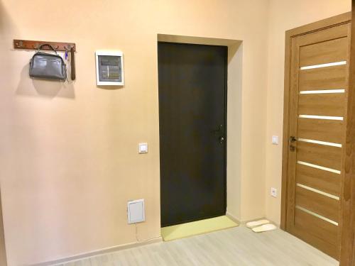 a room with a door and a television on a wall at Комфортные апартаменты Smart in Khmelëva