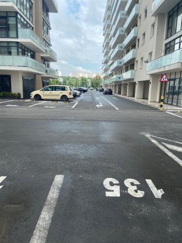 an empty street with cars parked in a parking lot at Iulius Mall Loft in Iaşi