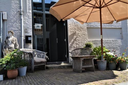 a patio with a table and chairs and an umbrella at B&B Appelsteiger in Dordrecht