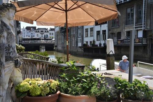 a man sitting at a table under an umbrella at B&B Appelsteiger in Dordrecht