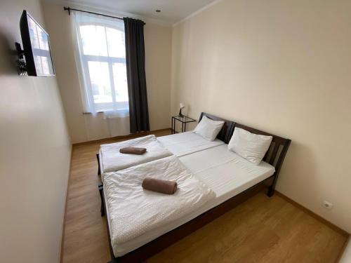 a bedroom with a bed with white sheets and a window at ApartHotel Riga in Rīga