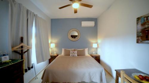Pérula的住宿－Casa Punta Perula VILLAS，一间卧室配有一张床和吊扇