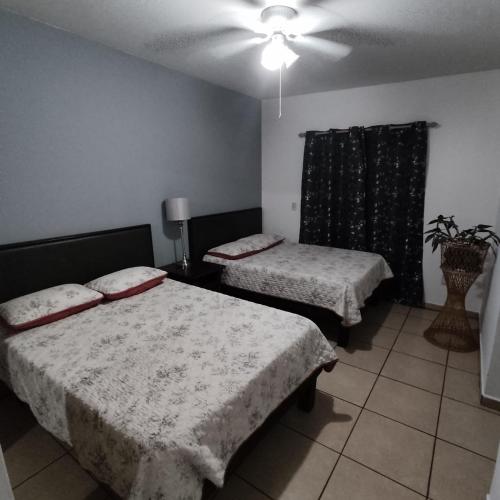 サン・カルロスにあるCasa Villa Serena 21のベッドルーム1室(ベッド2台、シーリングファン付)