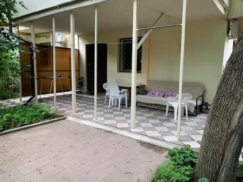 a patio with a couch and chairs on a house at Гостевой Дом у Моря, Guest House by the Sea in Odesa