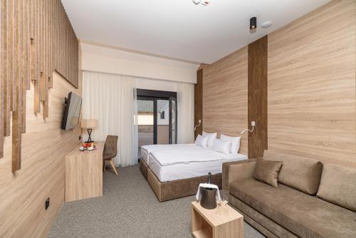 Habitación de hotel con cama y sofá en Holiday Park Zagyland, en Donja Konjšćina