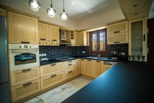 a kitchen with wooden cabinets and a black counter top at Villa Clairy in Argalasti, Pelion in Argalasti