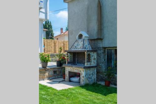 a stone fireplace in the yard of a house at Villa Clairy in Argalasti, Pelion in Argalasti